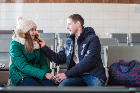 Couple in warm clothes in the waiting hall at the stationの写真素材
