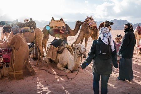 Wadi Rum, Jordan - December, 25, 2017: Tourists and Bedouins near camals in Wadi Rum desert in Jordanのeditorial素材