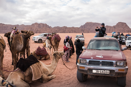 Wadi Rum, Jordan - December, 25, 2017: Tourists and Bedouins near camals in Wadi Rum desert in Jordanのeditorial素材