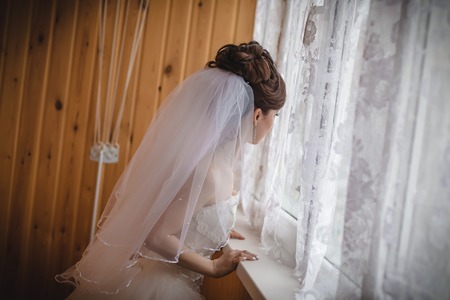 Portrait of slender bride in a white veil indoorsの写真素材
