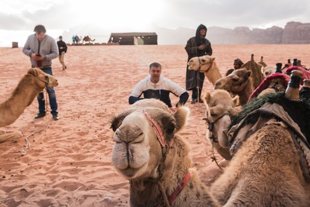 Wadi Rum, Jordan - December, 25, 2017: Tourists and Bedouins near camals in Wadi Rum desert in Jordanのeditorial素材