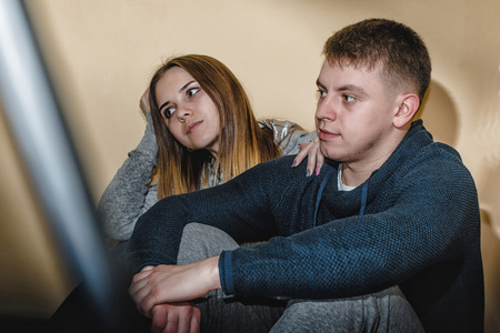 Adult teenagers boyfriend and girlfriend hugging each other in the corridor of an apartment buildingの写真素材