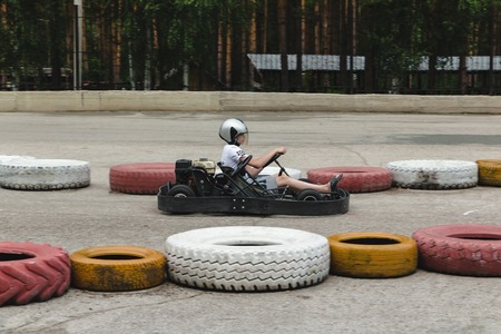 Abzakovo, Russia - August 01, 2016: Boy driving Go-kart car with speed in a playground racing track...