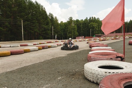 Abzakovo, Russia - August 01, 2016: Boy driving Go-kart car with speed in a playground racing track...
