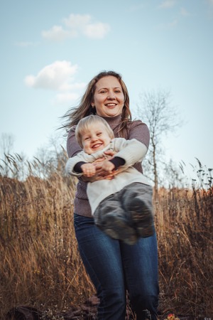 Mother and her baby have rest outdoors together in an autumn dayの写真素材