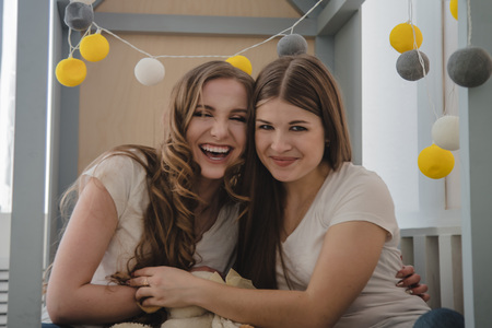 Two beautiful female friends are having fun in the room. Female friendshipの写真素材