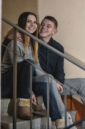 Homeless teenagers boyfriend and girlfriend sit on the steps in block of flatsの写真素材