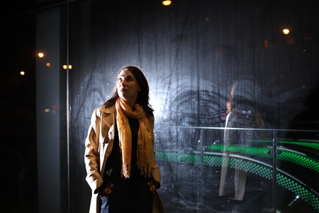 Girl brunette near in the shopwindow on the night city street in a cold time