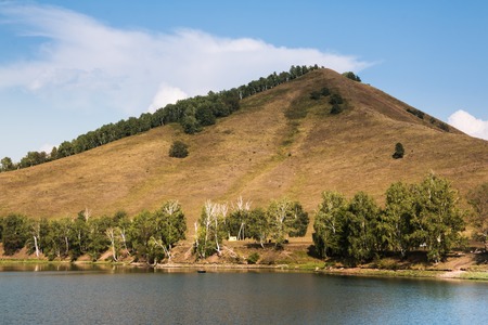 Landscape with clouds, mountain and lake in a summer day