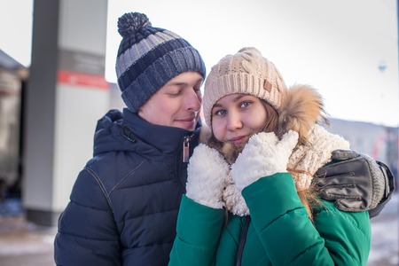 Portrait of happy couple hugging outdoors during winter dayの写真素材