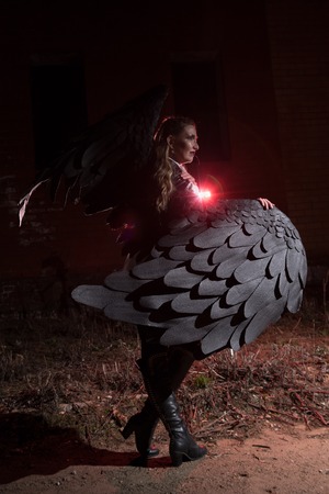Ungly woman with black wings. Angel in night city