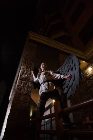 Ungly woman with black wings. Angel in night cityの写真素材