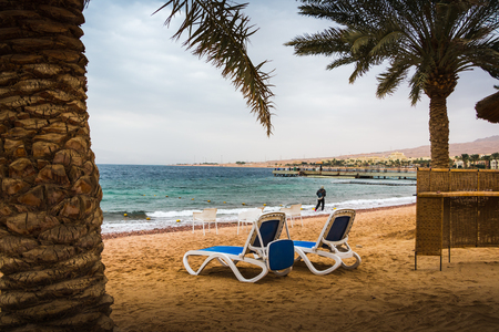 Bech with coconut trees and umbrellas in a Windy and cloudy dayの写真素材