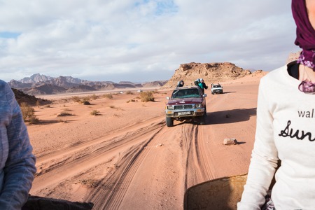Wadi Rum, Jordan - December, 25, 2017: Bedouin's car jeeps and tourists in it in Wadi Rum desert in...