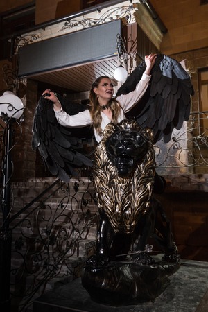 Ungly woman with black wings. Angel in night cityの写真素材