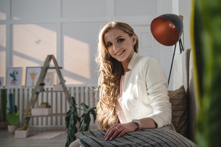 Pretty girl in white dress rest in the roomの写真素材