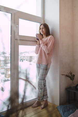 Cute girl in pink pajamas on the bed in sleeping roomの写真素材