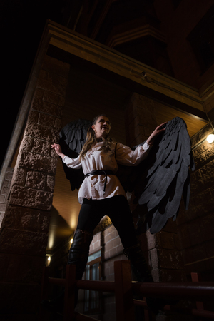 Ugly woman with black wings. Angel in night cityの写真素材
