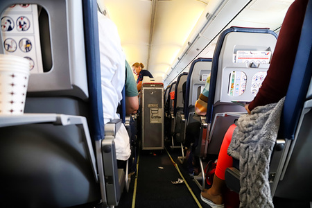 Kazan, Russia - May 19, 2018: Interior of airplane with passengers on seats and stewardess walking...