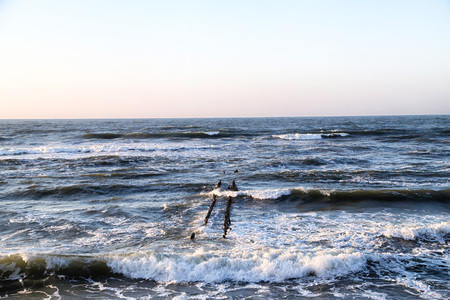 Sea landscape with rocky coastline during sunset. Waves splashing. Baltic sea.の写真素材