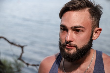 Handsome young man near sea on rocks in Turkey in a summer dayの写真素材