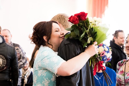 Kirov, Russia - June 15, 2018: Plump bride in green dress and groom in a black leather vest with guests after wedding ceremonyのeditorial素材
