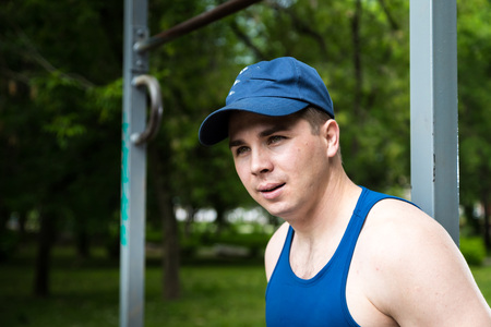 Portrait of attractive fitness man in a summer park
