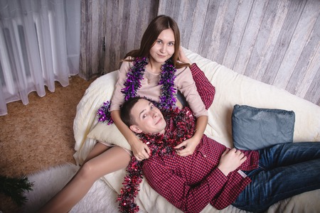 Young couple celebrating Christmas in the room decorated for Mary Christmas and New yearの写真素材