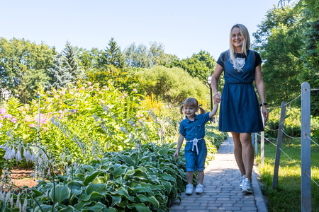 Cute blonde woman and her daughter in the park. Family with happy emotion.の写真素材