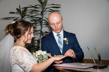 Kirov, Russia - July 27, 2018: Bride and groom are changing rings on their wedding. Ceremony in registration officeのeditorial素材