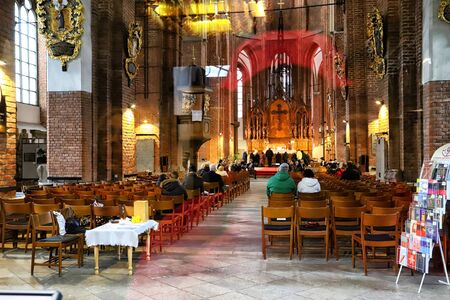 Riga, Latvia - April 01, 2018: The interior of the Church and the people during the service. Shot through glassのeditorial素材