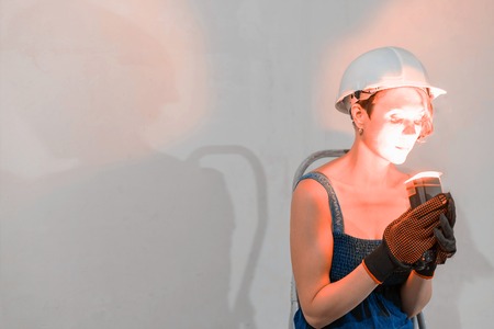 Sexy cute girl who is builder, painter, worker being in a renovated roomの写真素材