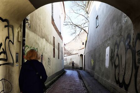 Vilnius, Lithuania - April 04, 2018: View of the old courtyard from the dark corridor.のeditorial素材
