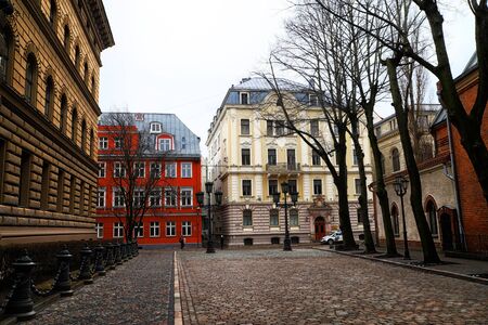 RIGA , LATVIA - April 01, 2018: Street and houses on it in old part of Riga city in cloudy spring...