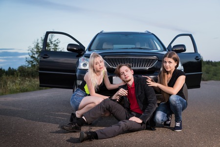 Two girls hitting male drunk pedestrian on the road in the summer evening. Photoshoot