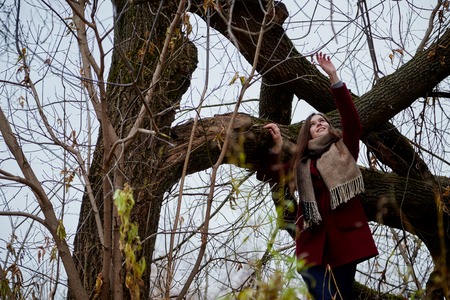Girl with long hair in a red coat in the Park in late autumnの写真素材