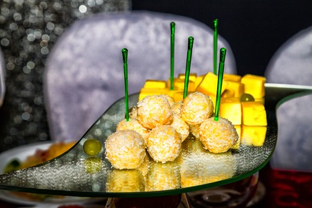Yellow cheese or chicken balls breaded on a glass plate on the tableの写真素材