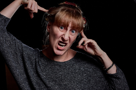 Woman with hair curlers and with funny emotion on the face. Anger, resentment, pain. Photoshoot in...