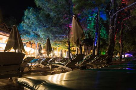 Empty sunbeds with umbrellas at dark night. Close up conceptの写真素材