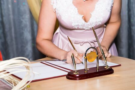 Kirov, Russia - October 12, 2018: Bride and groom signing marriage wedding certificate at registryのeditorial素材