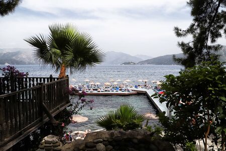 Marmaris, Turkey - May 22, 2018: Branches of trees and the sea and mountain view through them. Holiday conceptのeditorial素材