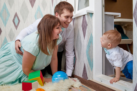 Couple with baby playing in the room. Mom, dad and son together. Photoshoot at homeの写真素材