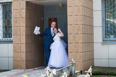 Kirov, Russia - July 27, 2018: Bride and groom near registry office before marriage registration in a summer dayのeditorial素材