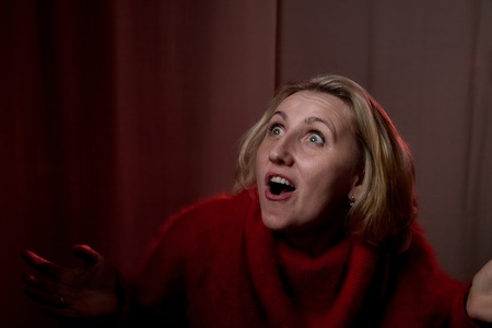 Portrait of a middle-aged woman in the room. Photography in the Studio. Photoshoot in a dark key
