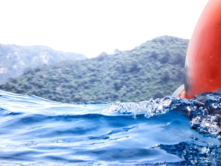 Sea surface with wave and drops and coast in the distance. View and shooting from water in a summer...