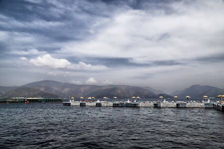 Marmaris, Turkey - May 22, 2018: View of sea, mountain and resting people on the pontoon. Holiday conceptのeditorial素材