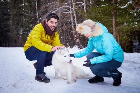 Happy loving couple in snowy winter forest. Ordinary Russian girl and handsome turkish man having...