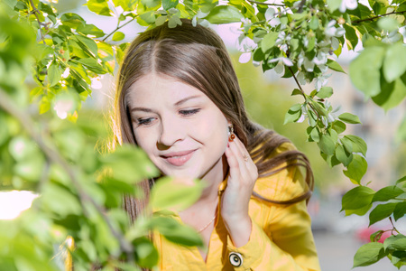 Beautiful young woman near blossoming apple treeの写真素材