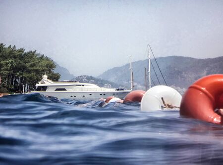 Marmaris, Turkey - May 21, 2018: Sea surface, waves, mountain coast in the distance and ship. View and shooting from water in a summer dayのeditorial素材
