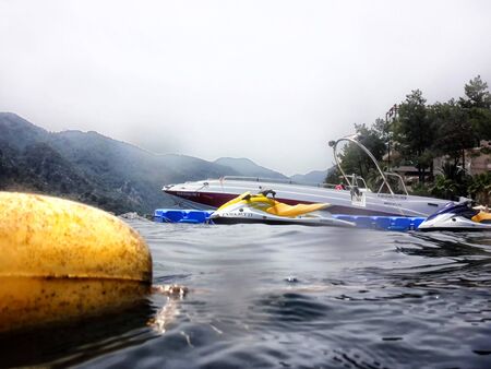 Marmaris, Turkey - May 21, 2018: Sea surface, waves, mountain coast in the distance and ship. View and shooting from water in a summer dayのeditorial素材
